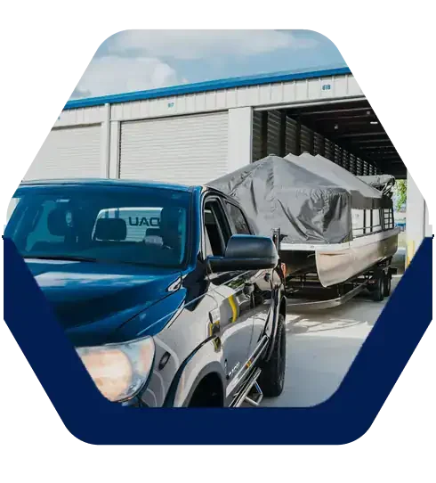 Truck pulling a covered pontoon boat into a drive-up storage unit at BattleCreek Storage in Broken Arrow, OK